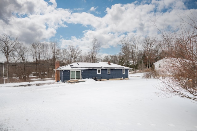 view of snow covered rear of property