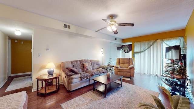 living room featuring a textured ceiling, ceiling fan, and dark hardwood / wood-style floors