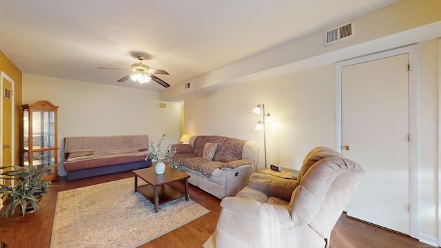 living room with ceiling fan and dark wood-type flooring