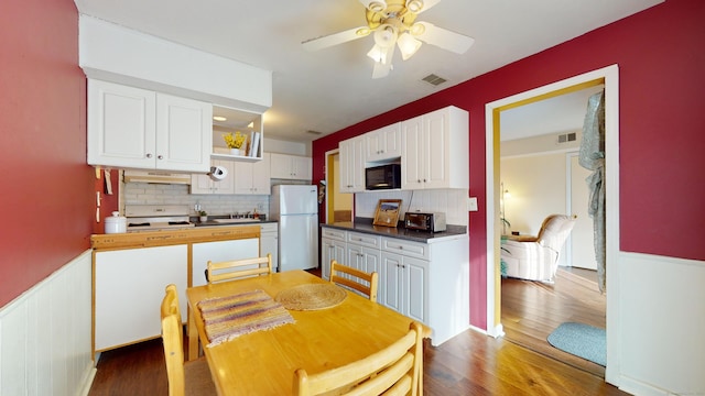 kitchen with tasteful backsplash, ceiling fan, white cabinets, and fridge