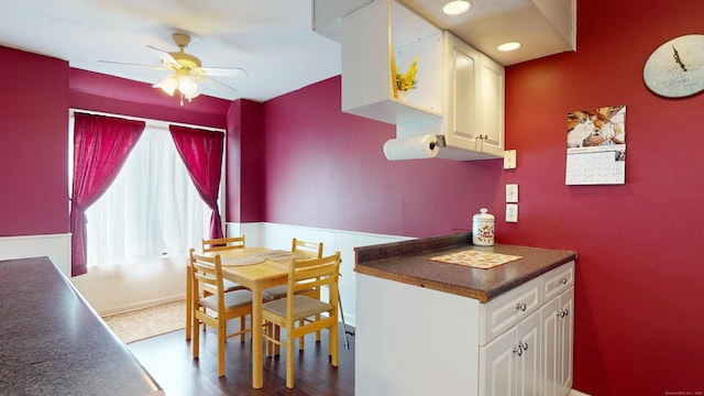 kitchen with ceiling fan, white cabinetry, and wood-type flooring