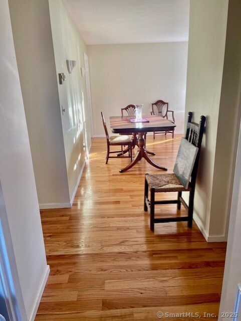 dining area featuring light wood-type flooring and baseboards