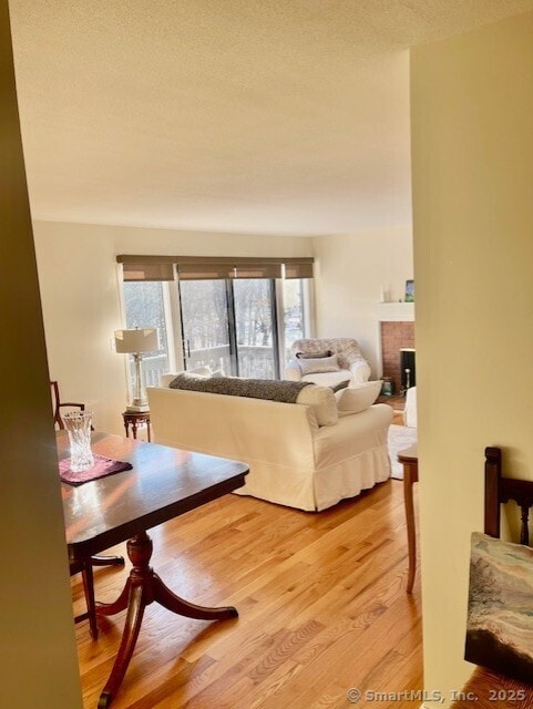 living area featuring a textured ceiling, a fireplace, and wood finished floors