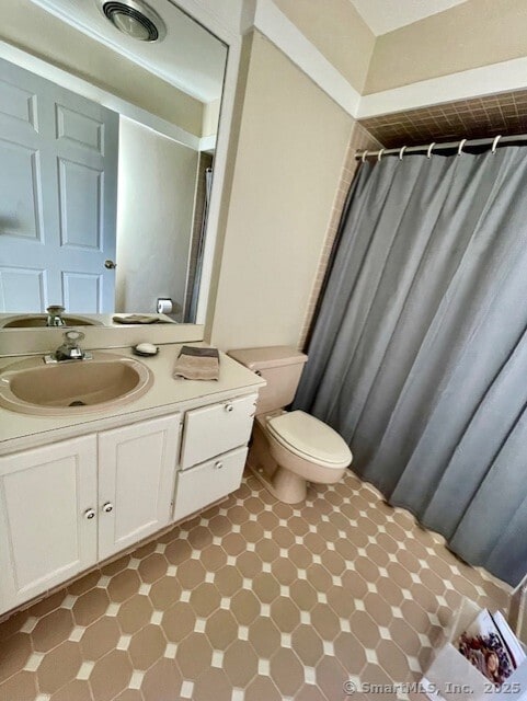 full bath featuring toilet, a shower with shower curtain, and vanity