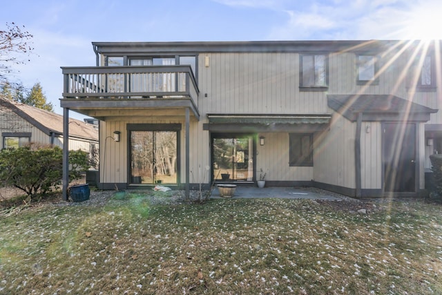 rear view of house featuring a yard and a balcony