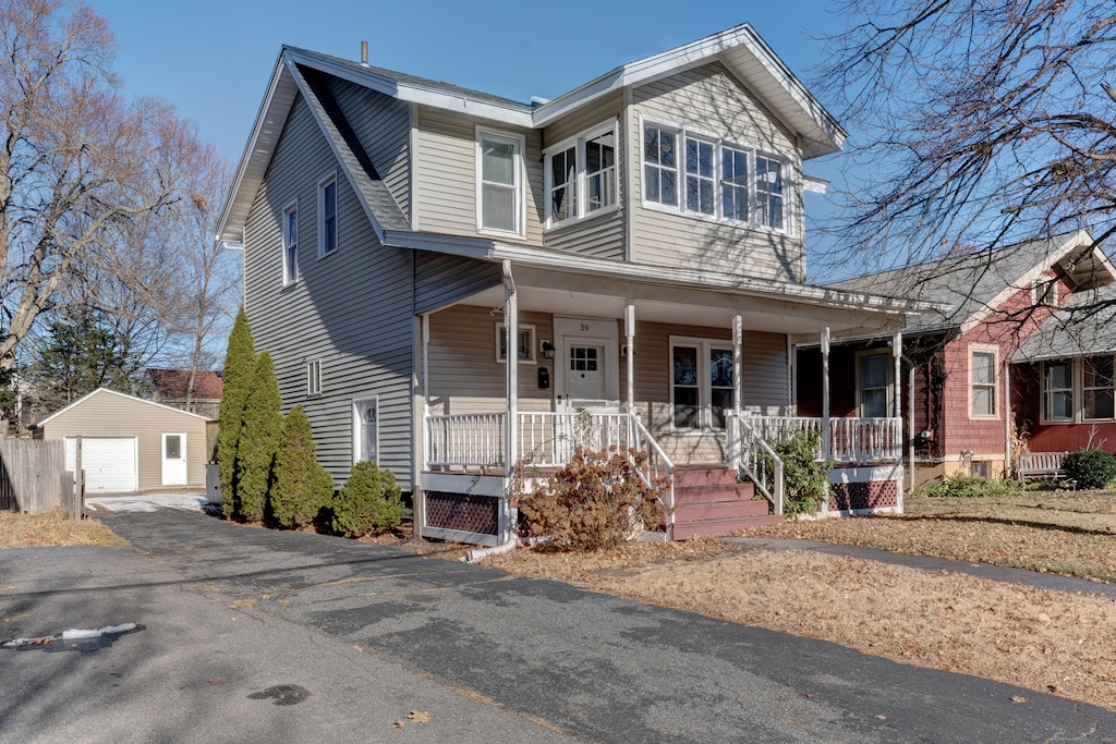 view of front facade with covered porch, a garage, and an outdoor structure