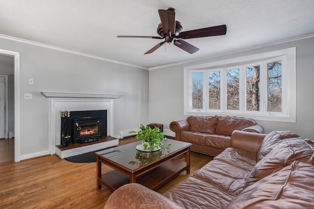 living room featuring ceiling fan, a baseboard radiator, ornamental molding, and hardwood / wood-style flooring