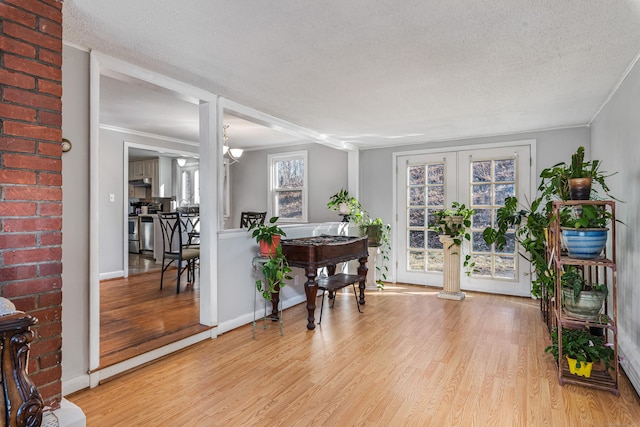 entryway featuring a textured ceiling, french doors, and light hardwood / wood-style flooring