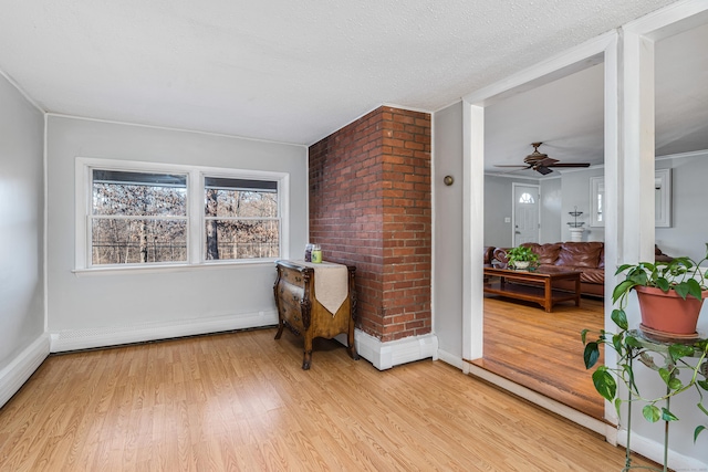 sitting room with ceiling fan, light wood-type flooring, a textured ceiling, and a baseboard heating unit