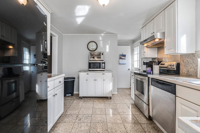 kitchen featuring stainless steel appliances, white cabinets, and decorative backsplash