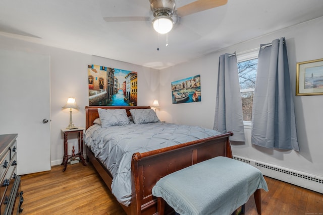 bedroom with a baseboard heating unit, ceiling fan, and light wood-type flooring