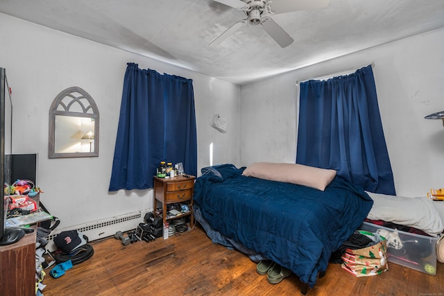 bedroom with baseboard heating, ceiling fan, and hardwood / wood-style flooring