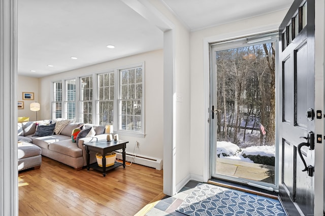 interior space featuring a baseboard heating unit, plenty of natural light, hardwood / wood-style flooring, and recessed lighting