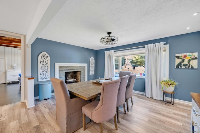 dining area with a textured ceiling and light wood-type flooring