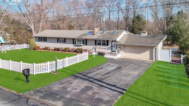 ranch-style house featuring a front yard, a playground, and a garage