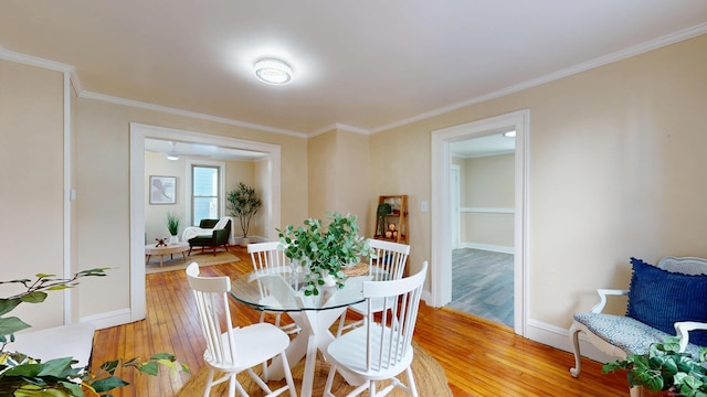 dining room featuring crown molding and light hardwood / wood-style flooring