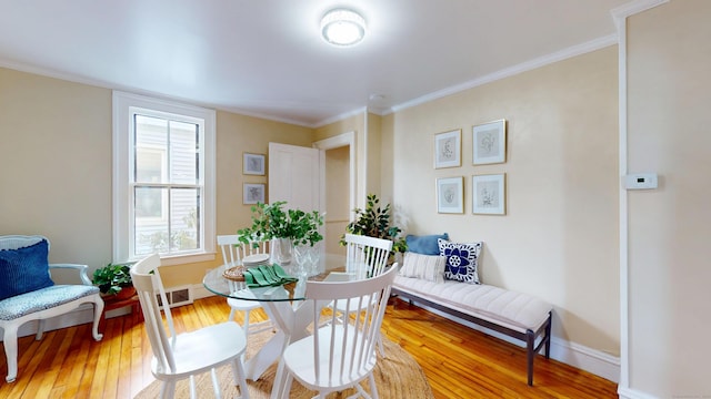 dining room with crown molding and wood-type flooring