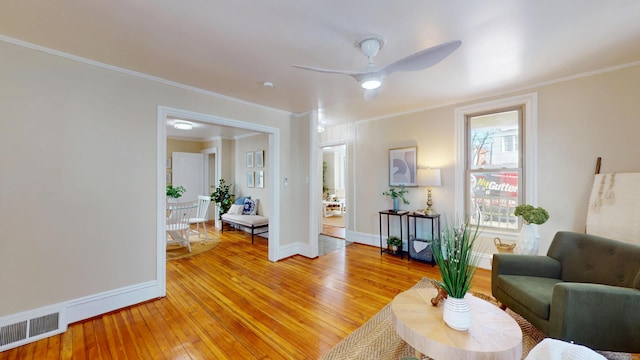 living room featuring ornamental molding, ceiling fan, and light hardwood / wood-style floors