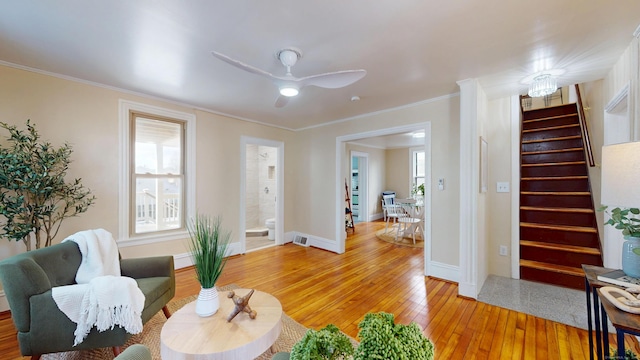 living area featuring crown molding, a healthy amount of sunlight, wood-type flooring, and ceiling fan