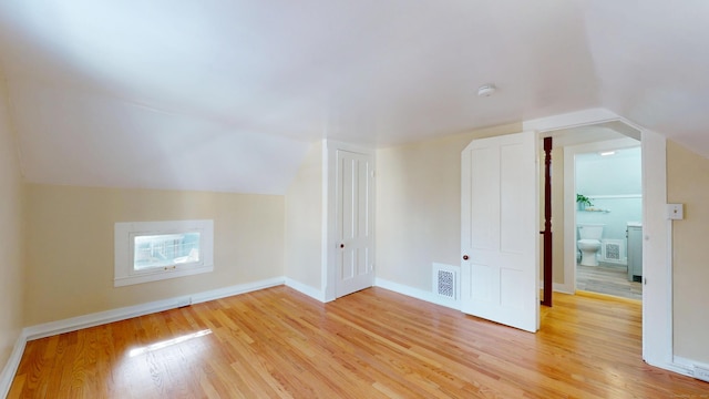 bonus room with lofted ceiling and light hardwood / wood-style floors