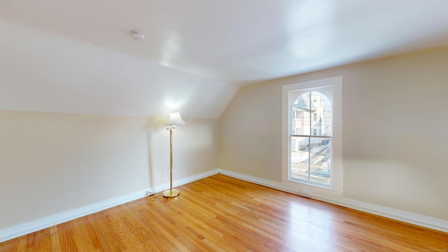 bonus room with hardwood / wood-style flooring and vaulted ceiling