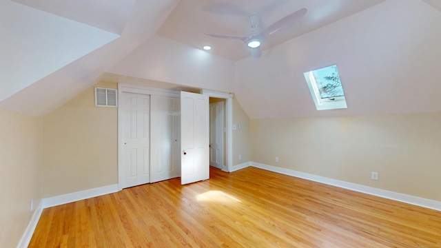 bonus room featuring light hardwood / wood-style flooring, lofted ceiling with skylight, and ceiling fan