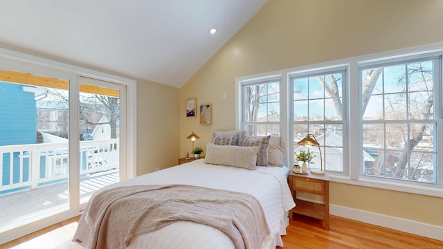 bedroom with multiple windows, light hardwood / wood-style flooring, and access to outside