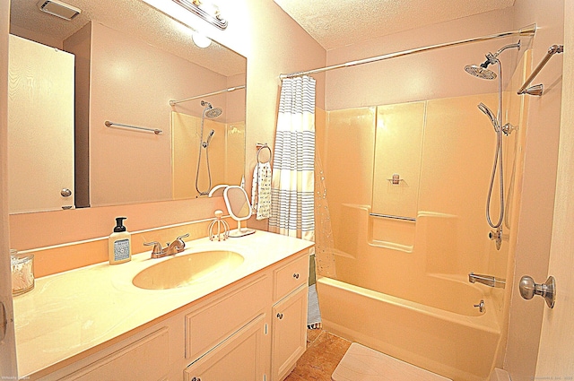 bathroom with vanity, a textured ceiling, and bathtub / shower combination