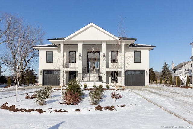 view of front facade with a garage, a balcony, and stucco siding