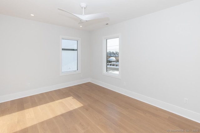 empty room featuring a ceiling fan, baseboards, and wood finished floors