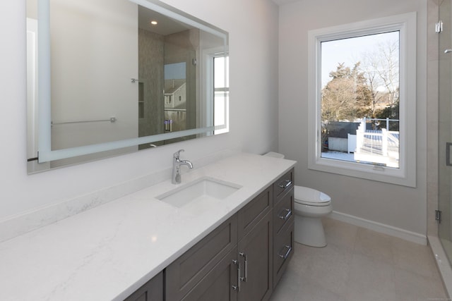 full bath featuring a stall shower, vanity, a wealth of natural light, and baseboards