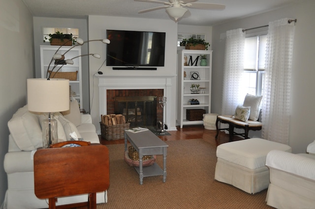 living room featuring ceiling fan and a brick fireplace