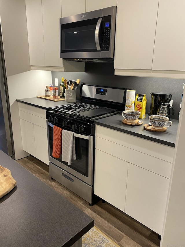 kitchen featuring appliances with stainless steel finishes and dark hardwood / wood-style floors