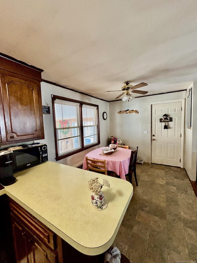 kitchen with ceiling fan, dark brown cabinetry, kitchen peninsula, and a textured ceiling