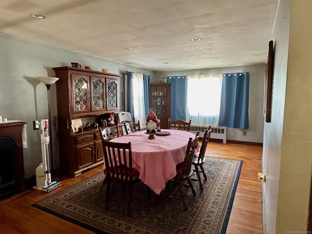 dining space with radiator and light hardwood / wood-style floors