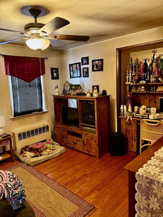 living room with radiator, wood-type flooring, and ceiling fan