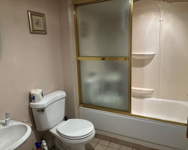 full bathroom featuring sink, shower / bath combination with glass door, and toilet