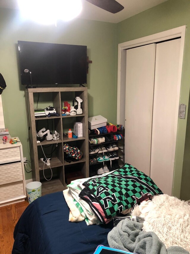 bedroom featuring ceiling fan, a closet, and hardwood / wood-style floors