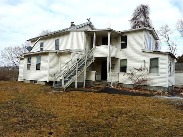 rear view of property featuring a lawn