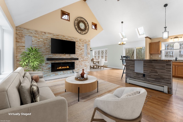 living room featuring light wood-type flooring, sink, high vaulted ceiling, and a baseboard radiator