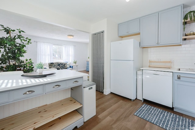 kitchen with white appliances, sink, light hardwood / wood-style flooring, and decorative backsplash