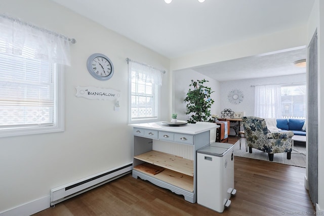 interior space featuring baseboard heating, dark hardwood / wood-style floors, and a center island