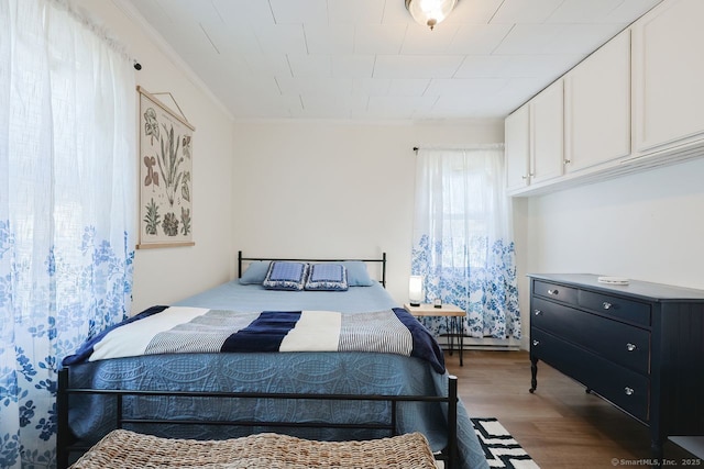 bedroom featuring baseboard heating, crown molding, and dark wood-type flooring