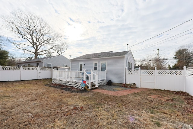 rear view of property featuring a lawn and a wooden deck