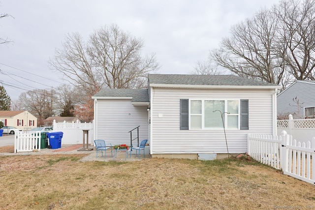 back of property featuring a lawn and a patio