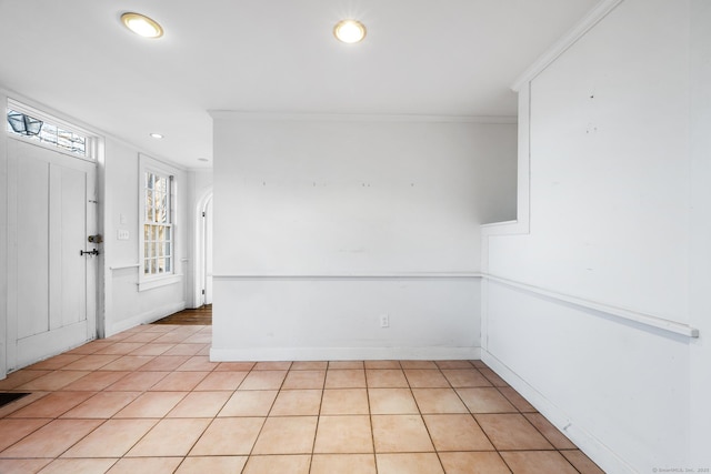 unfurnished room featuring light tile patterned floors and crown molding