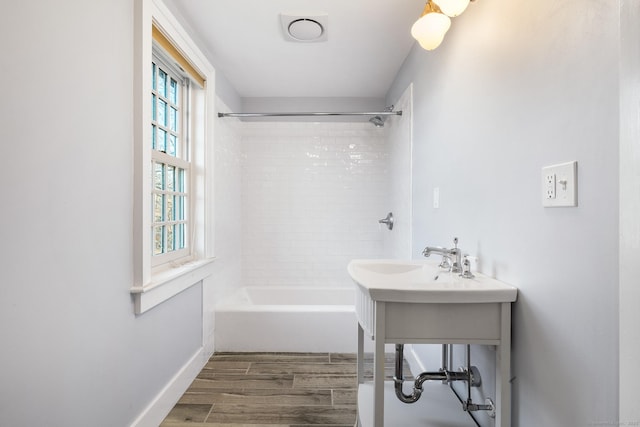 bathroom featuring tiled shower / bath combo and a healthy amount of sunlight