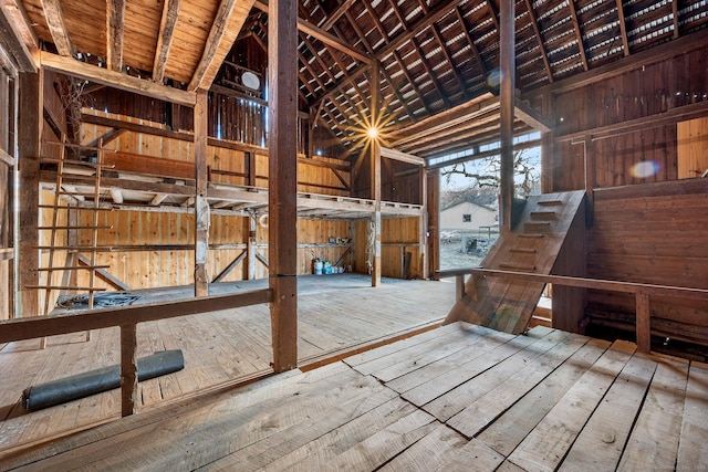 misc room with wood ceiling, wood walls, hardwood / wood-style flooring, high vaulted ceiling, and beam ceiling