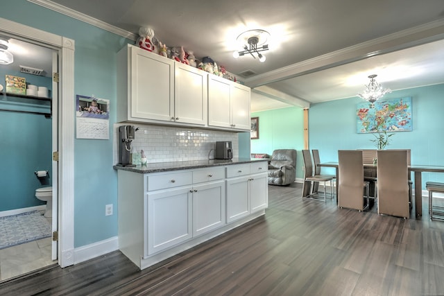 kitchen featuring dark stone countertops, decorative backsplash, dark wood-type flooring, and white cabinets