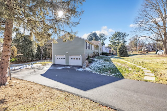 view of home's exterior with a garage and a yard